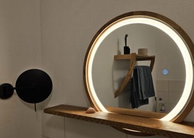 Blick auf einen modernen Holz-Spiegel mit integrierter LED-Beleuchtung, perfekt für Badezimmerdekoration und Make-up, mit stilvollem Wandlampen-Design.