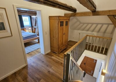 Treppenhaus mit Holzmöbeln und Dachbalken