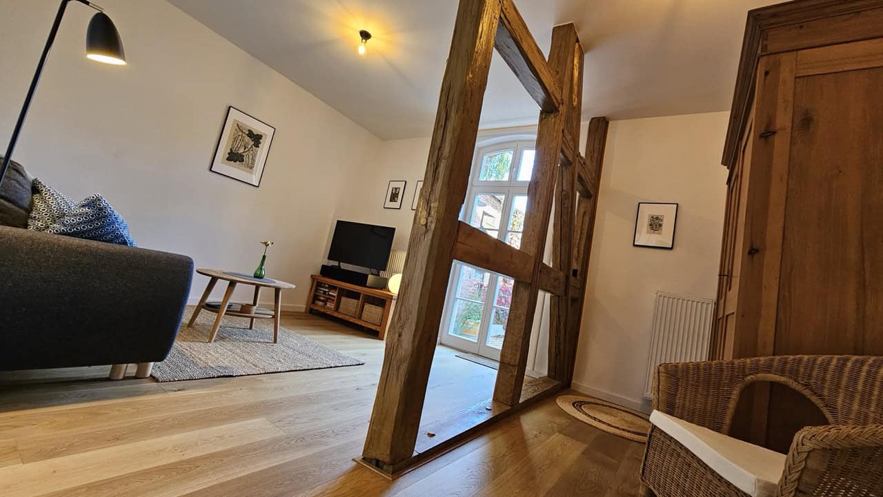 Wohnzimmer 2 Gemütliches Wohnzimmer mit rustikalen Holzelementen, moderner Einrichtung, Fernseher und gemütlicher Atmosphäre – ideal für einen entspannten Aufenthalt im Ferienhaus zur Zitadelle.